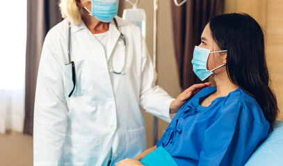 Senior woman doctor wearing protective mask with stethoscope service help support discussing and consulting talk to sick woman patient about checkup result information in hospital