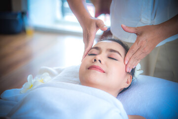 Obraz na płótnie Canvas Beautiful woman during facial massage in spa salon, Close up of asian woman. She is feeling relax and happy.