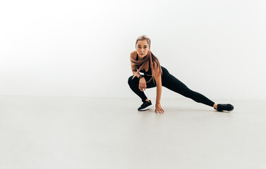 Fototapeta na wymiar Sportswoman doing stretching exercises indoors before training