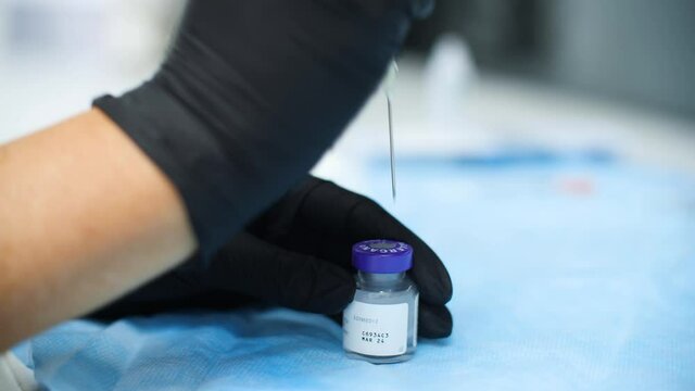 Botox is drawn out by syringe from a closed glass Botox bottle
