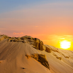 Fototapeta na wymiar sandy dune slope in light of red dramatic sunset