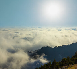 mount slope silhouette in dense clouds under sparkle sun, natural mountain background