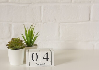 September 4. Wooden calendar on a white brick background with an empty space. The concept of returning to school.