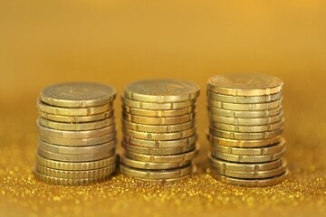 Money and finance.Coins columns in gold glitter on a golden background.  savings symbol 