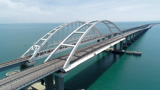 Beautiful suspension bridge over blue water. Shot. Highway on large suspension bridge passing through sea section. Crimean suspension bridge over turquoise water