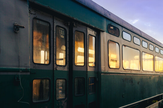 Abandoned damaged railcar at sunset