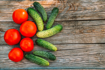 Cucumbers and tomatoes on a wooden background. Harvesting from the garden. Eco products. Farming
