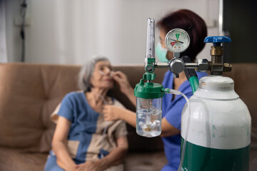 Elderly woman wearing oxygen nasal canula at home.