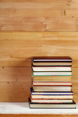 Stack of old books on a wooden shelf