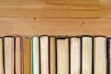 Stack of old books on a wooden shelf