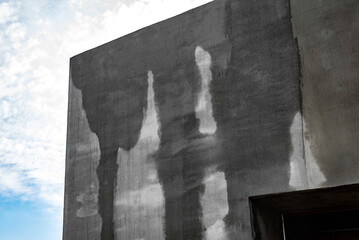 Covered with mesh and glue facade of the house with water.