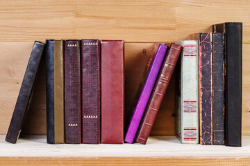 Stack of old books on a wooden shelf