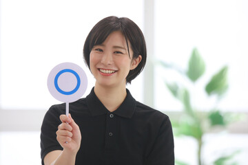 〇札を持つスポーツジムインストラクター