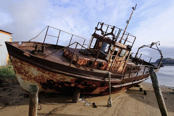 A rusty boat on the shore of the White Sea. The ship is stranded. North