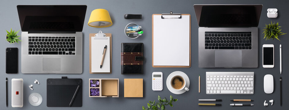 Flat lay top view office desk working space with laptop on gray background.