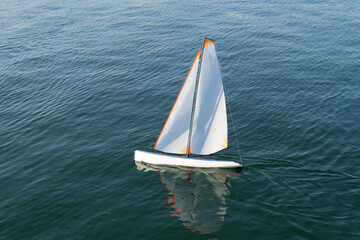 Freedom of sail. Toy yacht sail in sea. Sailing toy boat on sea surface. Yachting and sailing....