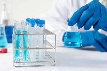 Doctor holding test tube with sample for analysis in laboratory, closeup