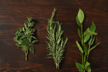Various herbs and spices on wooden background, top view. Cooking background: knife, coriander, laurel on dark rusty background with copy space.