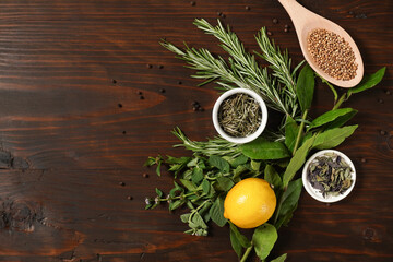 Assorted spices with fresh herbs on a wooden background. Natural food additives. Aromatic herbs and spices from garden, healthy cooking concept. Flat lay, top view