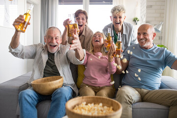 Group of senior friends watching movie indoors, party, social gathering and having fun concept.
