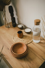 Interior in bohemian style with wooden plates, organic candles on a wooden table.