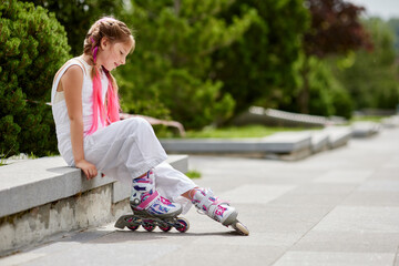 cute little girl on roller skates at park.