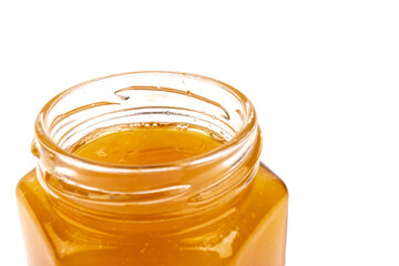 Glass jar full of sweet honey isolated on white background