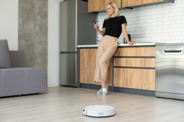 Fototapeta na wymiar Modern life concept, woman relaxing , automatic robotic hoover clean the room while