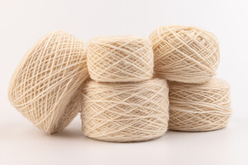 balls of light woolen thread on white background. natural wool. knitting. background