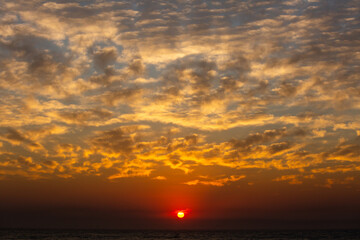 dramatic clouds and bright sunset over the ocean on an island