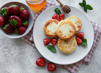 Cottage cheese pancakes, ricotta fritters on ceramic plate with  fresh strawberry.