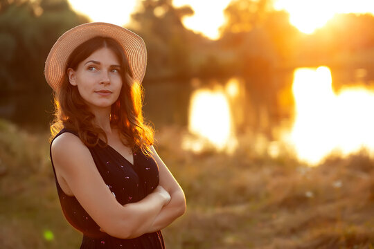 Vintage photo of relaxing young woman in straw hat in nature on sunset. Cheerhul, freedom, happiness, relax, no makeup concept