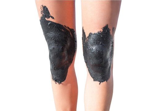 Women's legs with knees smeared with therapeutic mud, isolated on white background with clipping path.