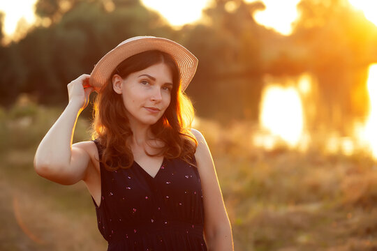 Vintage photo of relaxing young woman in straw hat in nature on sunset. Cheerhul, freedom, happiness, relax, no makeup concept