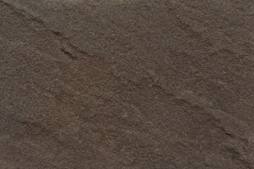 Fototapeta na wymiar Natural stone texture. Brown rough textured rock close up with space for text. Weathered grunge granite texture