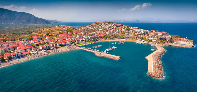 Panonoramic view from flying drone of Astros port. Sunny summer seascape of Myrtoan Sea. Aerial urban scene of Arcadia region, Greece, Europe. Traveling concept background.