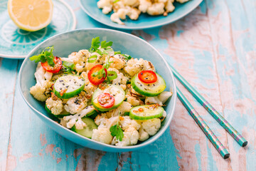 Asian salad with roasted cauliflower, cucumber, onion and chili