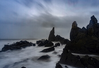 Beautiful Long exposure Image of the ocean waves hitting the big sharp rocks at the beach side of Arambol beach, Goa.