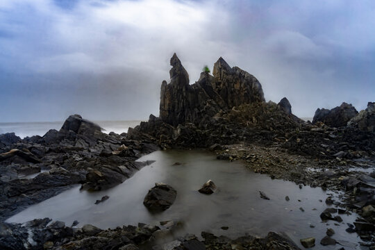 Beautiful Long exposure Image of the ocean waves hitting the big sharp rocks at the beach side of Arambol beach, Goa.