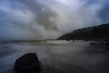 Beautiful Long exposure Image of the ocean waves hitting the big sharp rocks at the beach side of Arambol beach, Goa.
