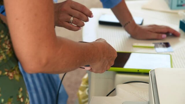 Woman paying contactless after undergoing covid swab at a medical center outdoor