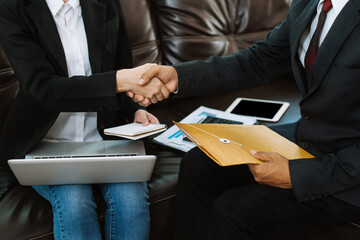 Business men and women shake hands confidently professional investor working with new startup project at an office meeting.