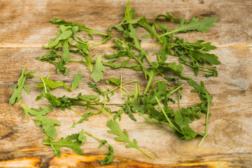 Arugula herb prepared on wooden board.