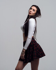 Woman in plaid skirt in the form of a schoolgirl on a white isolated background
