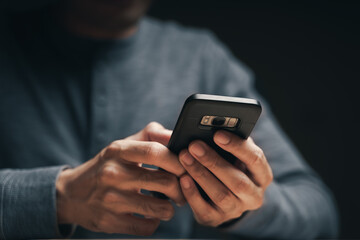 Closeup of a man using a smartphone on the wooden table, searching, browsing, social media, message, email, internet digital marketing, online shopping..