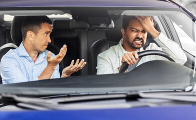 driver courses and people concept - driving school instructor talking to sad man failed exam in car