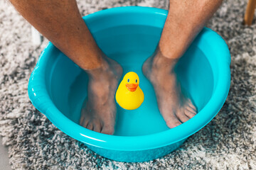 Man soaking his feet in a basin