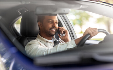 transport, communication and people concept - smiling indian man or driver driving car and calling on smartphone