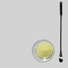 Optiblanc powder in chemical watch glass placed next to the stirring rod. Chemical for beauty care on laboratory table (Top View).