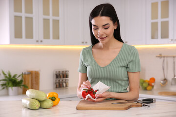 Woman wiping tomatoes with paper towel in kitchen